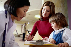 Mom and daughter filling out paperwork with doctor