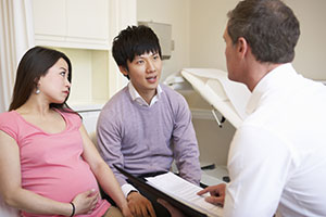 Pregnant couple talking to doctor