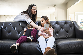 Mom taking smartphone away from young kids