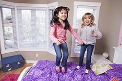 Kids jumping on a bed
