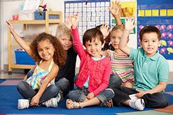 kids raising their hands in class